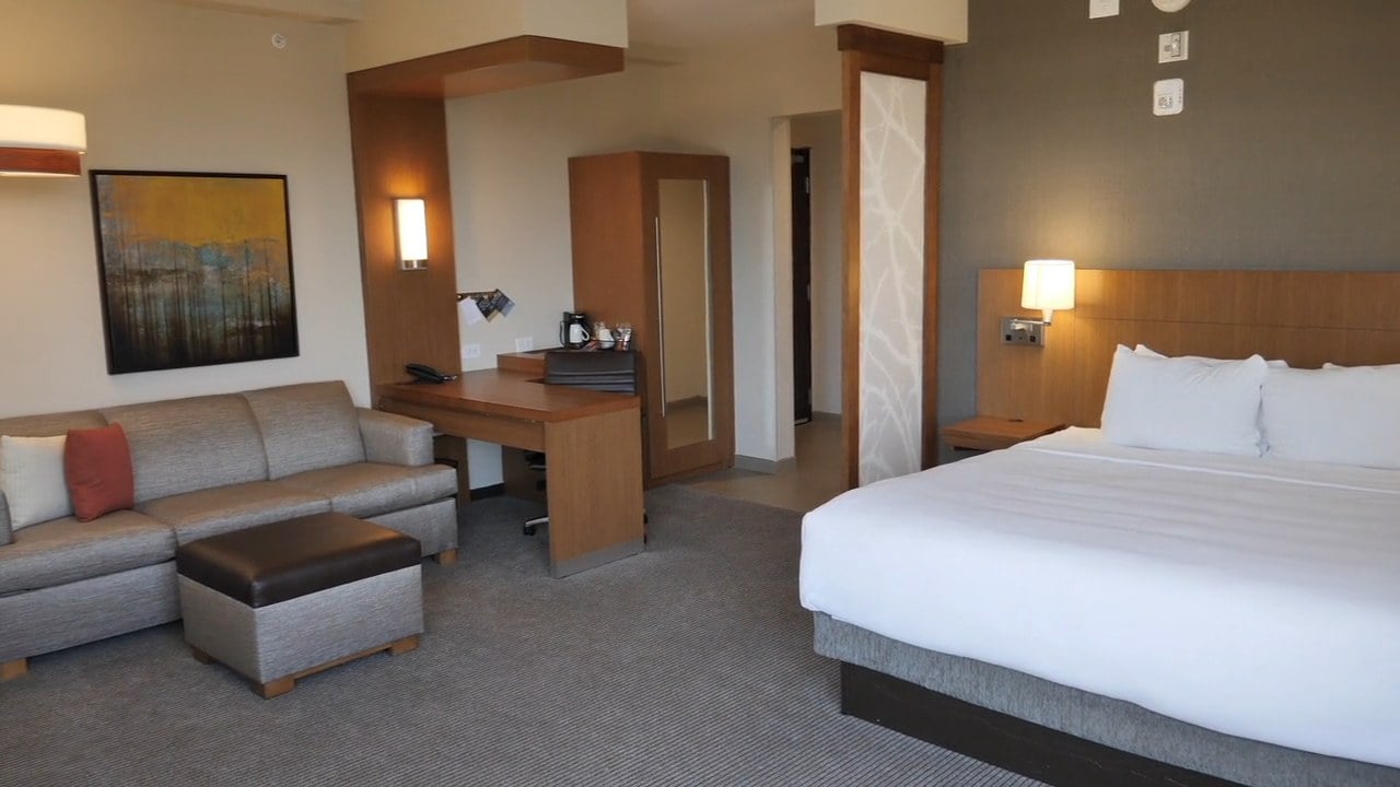 Video tour of a studio room with a king bed, sofa and work desk