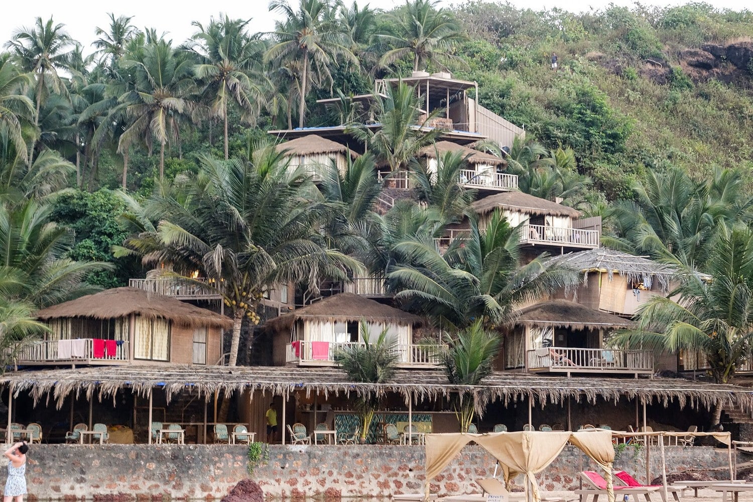 Cottages and a restaurant among palm trees at a Goa beach resort